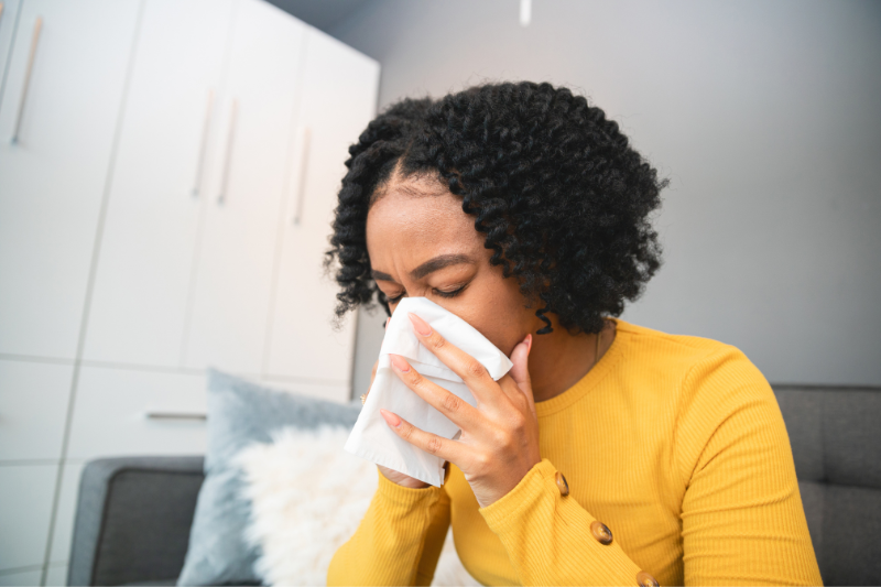 Woman experiencing allergies at home due to a dirty AC