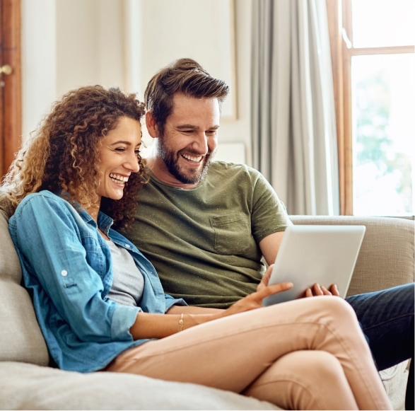 Happy couple looking at finance options on laptop